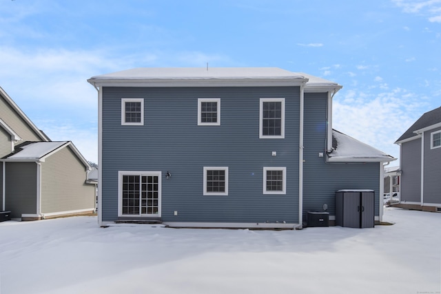 snow covered property with central air condition unit