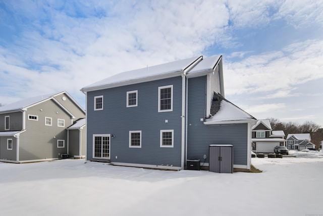 snow covered property featuring central AC unit