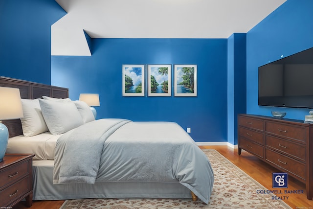 bedroom featuring baseboards and wood finished floors