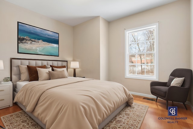 bedroom with light wood-type flooring, baseboards, and visible vents