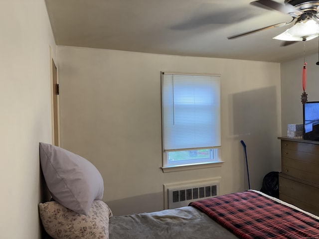 bedroom featuring radiator heating unit and a ceiling fan