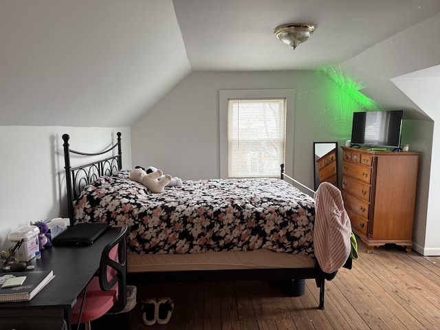 bedroom featuring hardwood / wood-style floors and lofted ceiling