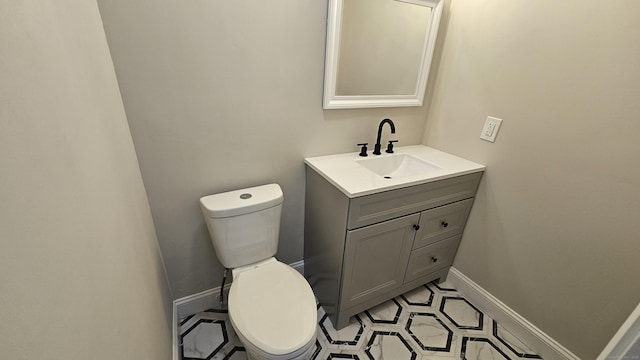 bathroom featuring vanity, toilet, and baseboards