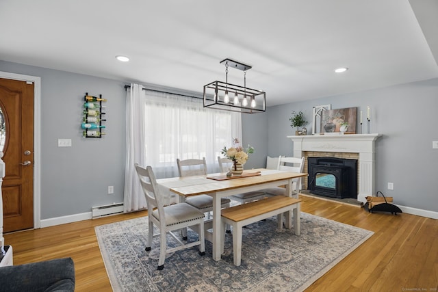 dining space featuring a baseboard heating unit, recessed lighting, baseboards, and light wood finished floors