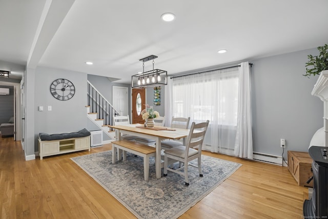 dining space featuring light wood-style floors, recessed lighting, a baseboard heating unit, and stairs