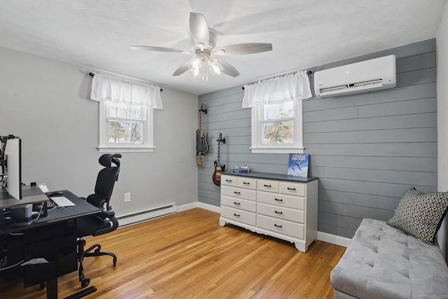 home office with light wood-type flooring, a baseboard heating unit, a wealth of natural light, and a wall mounted AC