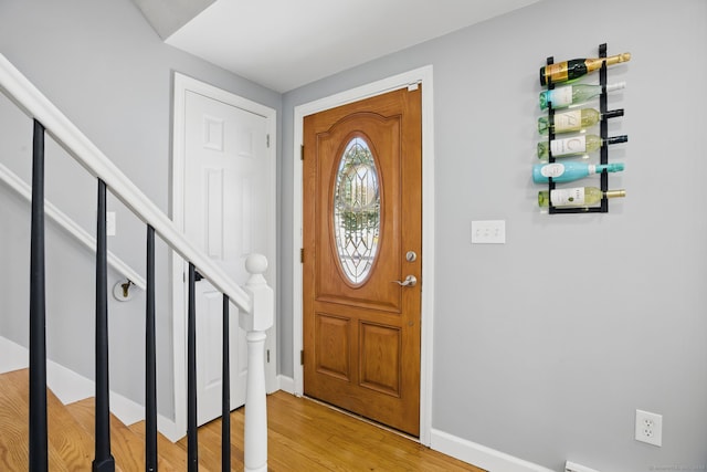 foyer featuring stairs, baseboards, and wood finished floors