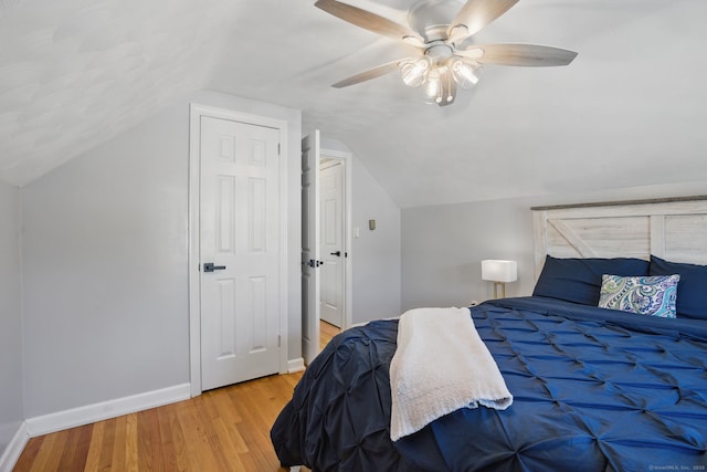 bedroom featuring vaulted ceiling, wood finished floors, a ceiling fan, and baseboards