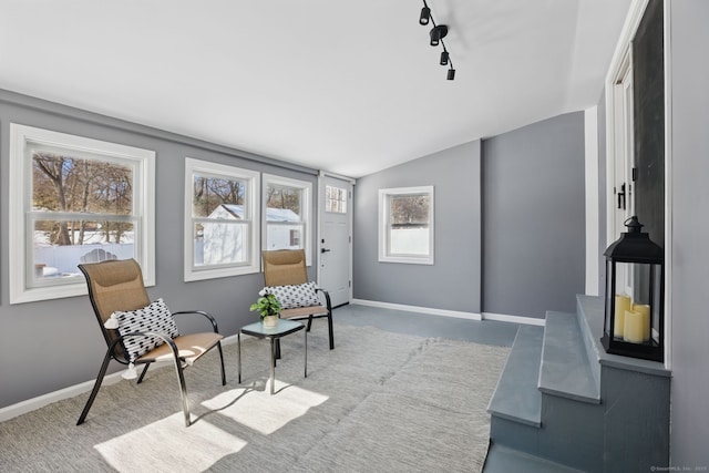 living area with plenty of natural light, baseboards, and vaulted ceiling