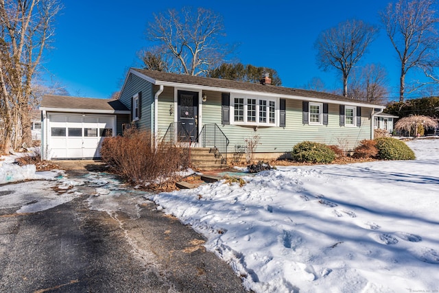 single story home with a garage, driveway, and a chimney