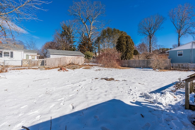 yard layered in snow featuring fence