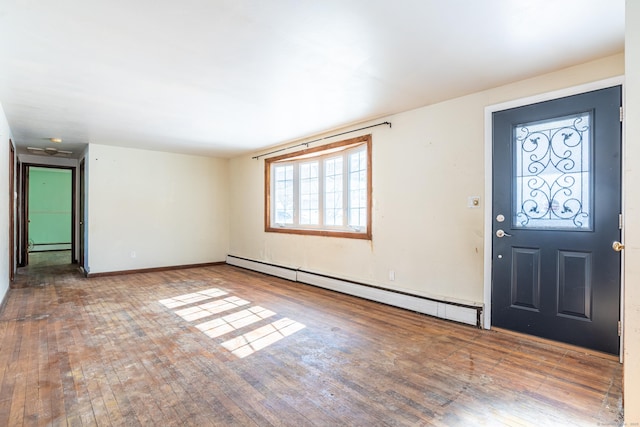 foyer entrance with a baseboard radiator, baseboards, and wood finished floors