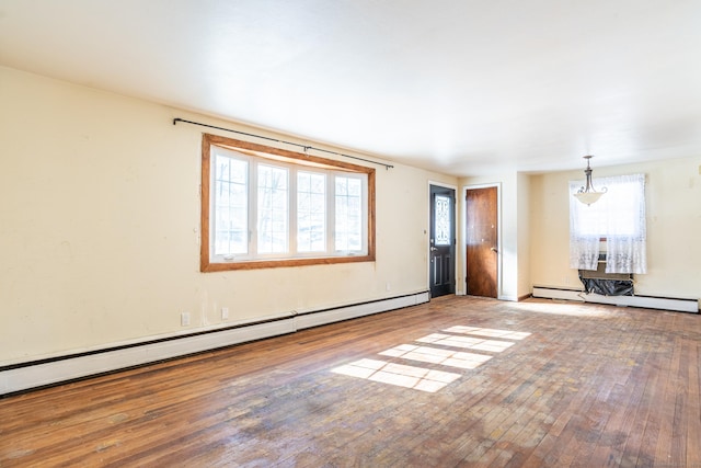 unfurnished living room featuring baseboard heating and wood finished floors