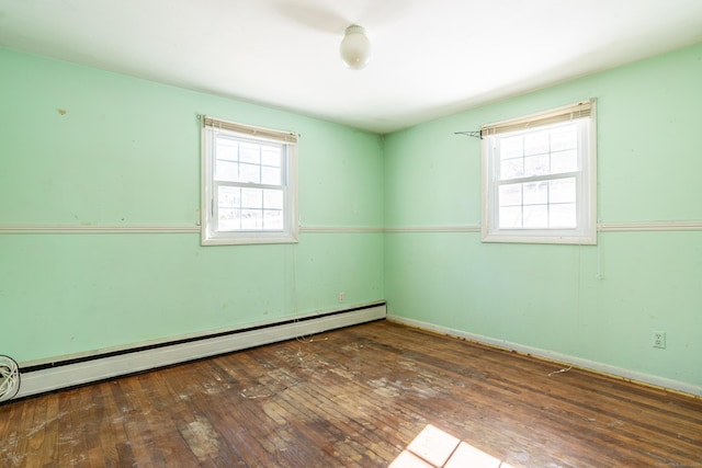 empty room with dark wood-type flooring and a baseboard radiator