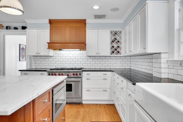 kitchen featuring stainless steel appliances, ornamental molding, visible vents, and white cabinets