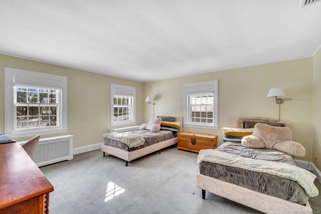 carpeted bedroom with radiator heating unit, visible vents, and baseboards