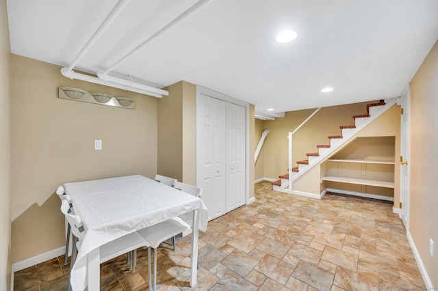 finished basement featuring recessed lighting, stone finish floor, stairway, and baseboards