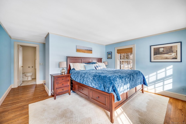 bedroom featuring light wood-style floors, ornamental molding, and baseboards