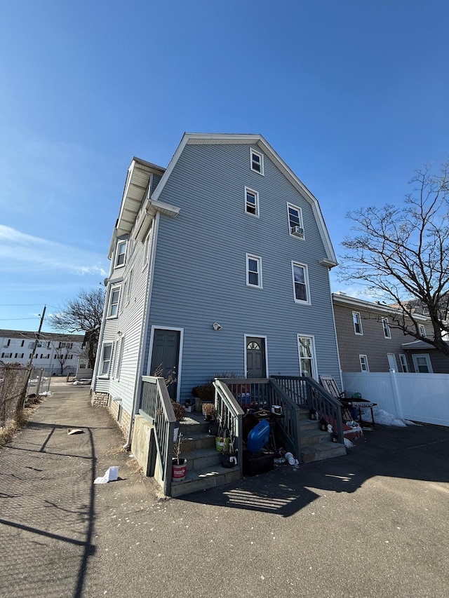 rear view of house featuring fence