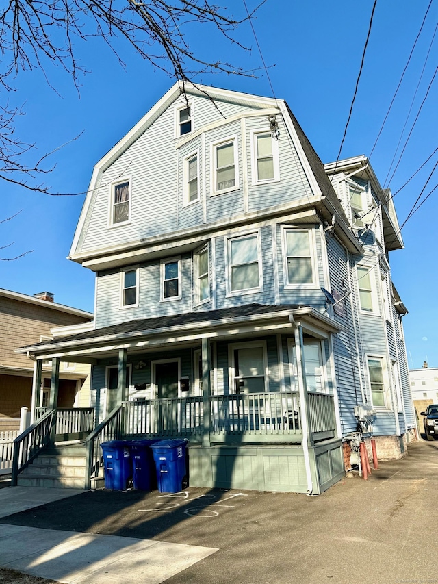 view of front of house featuring covered porch and a gambrel roof