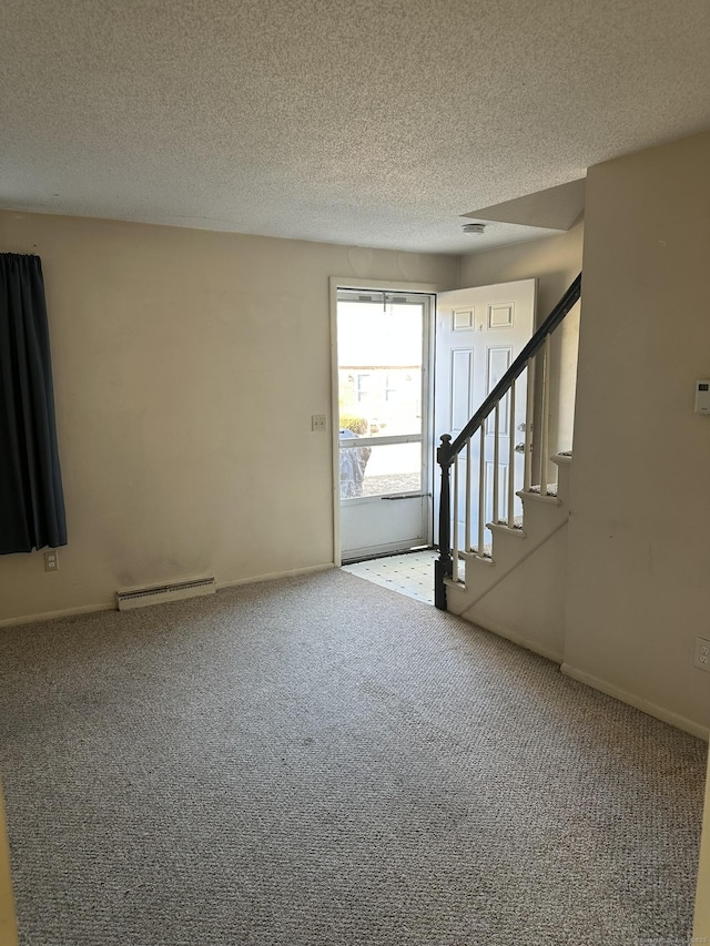 carpeted entrance foyer featuring stairs, a textured ceiling, a baseboard radiator, and baseboards