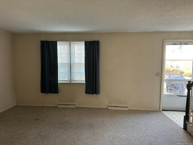 empty room with a baseboard heating unit, carpet floors, a textured ceiling, and visible vents