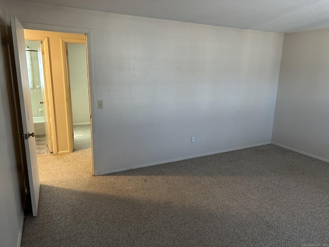 carpeted spare room with baseboards