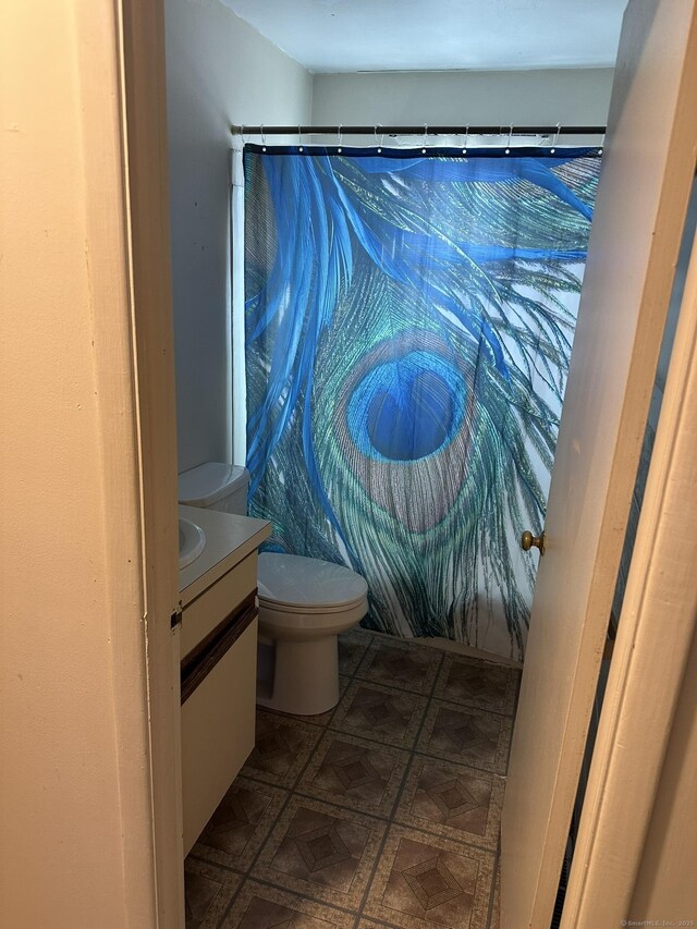 full bathroom featuring toilet, curtained shower, and vanity