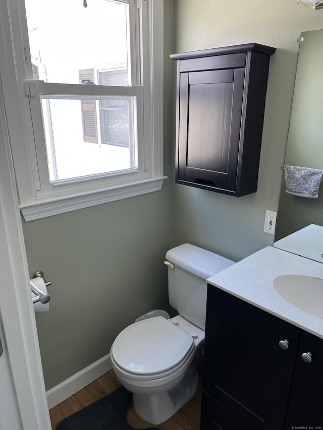 bathroom with toilet, hardwood / wood-style flooring, and vanity