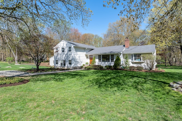 view of front of house with a front lawn and a chimney