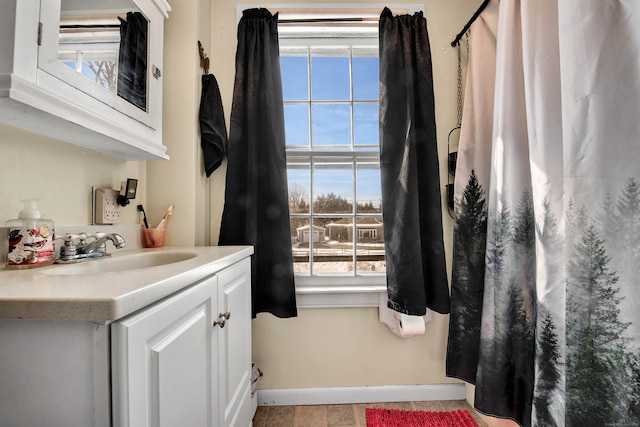 bathroom with vanity, curtained shower, and baseboards