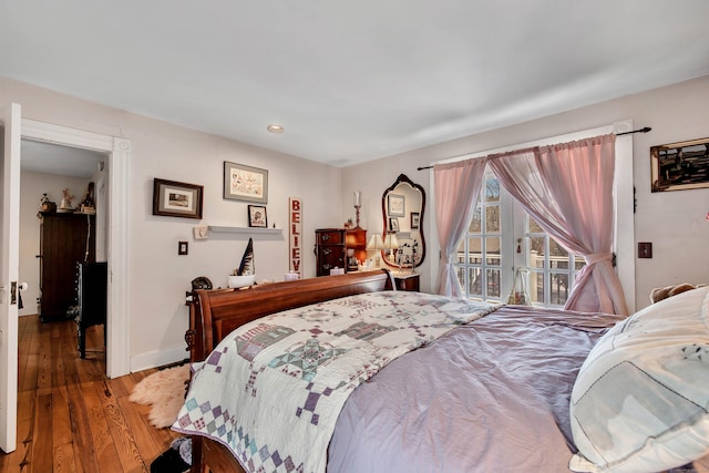 bedroom featuring hardwood / wood-style floors, access to exterior, recessed lighting, and baseboards