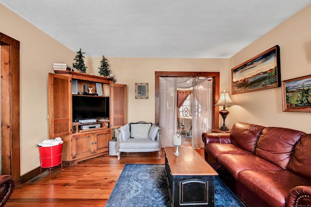 living room featuring hardwood / wood-style flooring, baseboards, and a textured ceiling