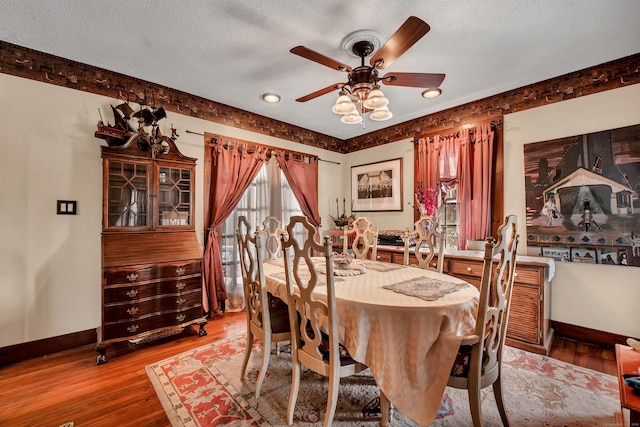 dining space featuring baseboards, a textured ceiling, ceiling fan, and light wood finished floors