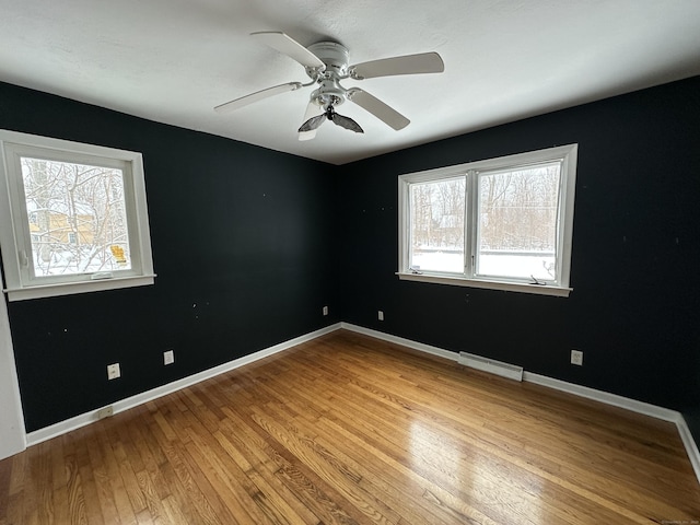 159 Tom Swamp Rd, Hamden, CT 06518 - spare room featuring a baseboard heating unit, ceiling fan, baseboards, and hardwood / wood-style floors