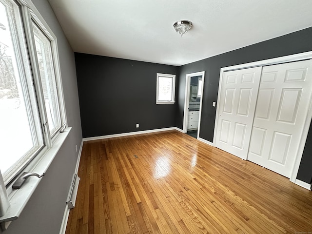 159 Tom Swamp Rd, Hamden, CT 06518 - unfurnished bedroom featuring a closet, baseboards, and light wood finished floors