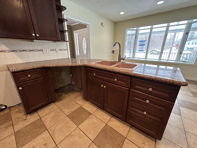 159 Tom Swamp Rd, Hamden, CT 06518 - kitchen with stone counters, tasteful backsplash, a sink, dark brown cabinets, and a peninsula