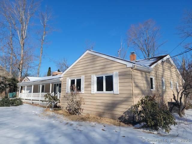 159 Tom Swamp Rd, Hamden, CT 06518 - view of snow covered exterior with a porch and a chimney