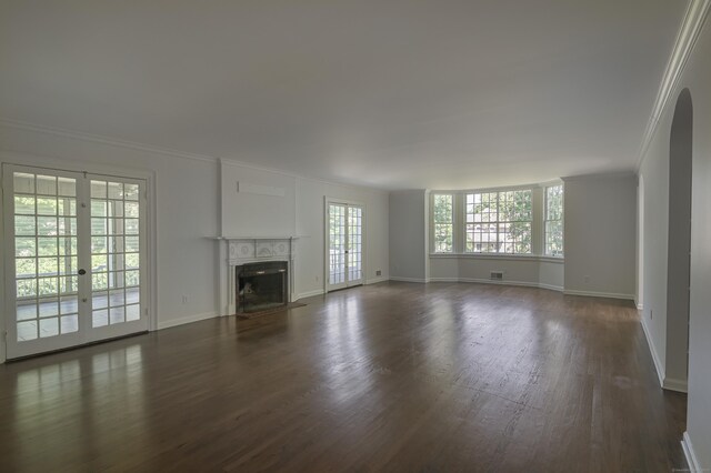 unfurnished living room featuring a fireplace with flush hearth, baseboards, french doors, dark wood finished floors, and crown molding