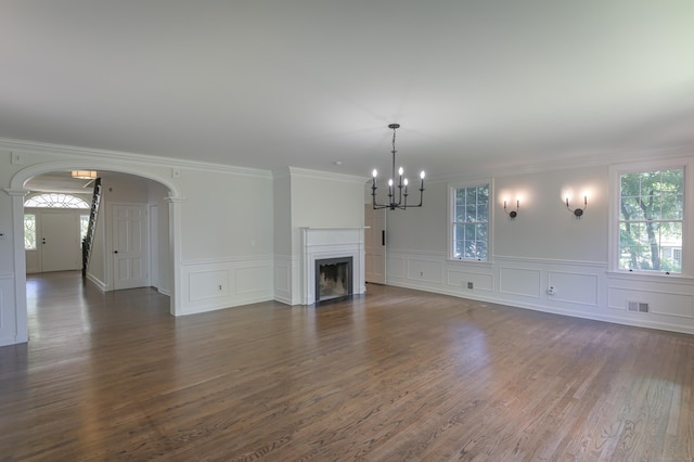 unfurnished living room featuring visible vents, a fireplace, arched walkways, and dark wood-style flooring