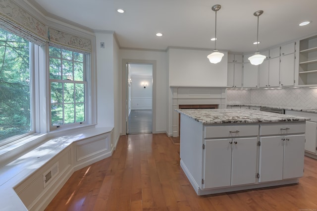 kitchen featuring open shelves, a kitchen island, white cabinets, and hanging light fixtures