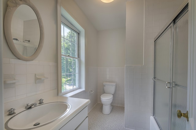 full bathroom featuring tile patterned flooring, toilet, a baseboard heating unit, vanity, and tile walls