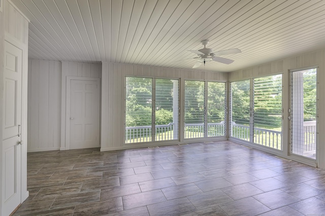 unfurnished sunroom with wood ceiling and a ceiling fan