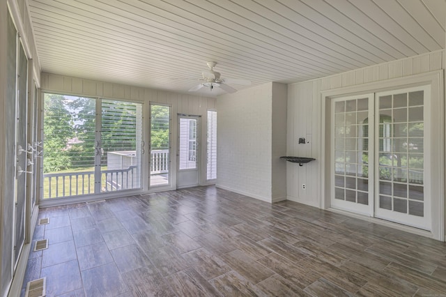 unfurnished sunroom with a ceiling fan, wood ceiling, and visible vents