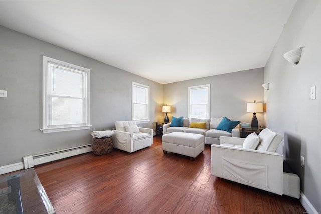 living area with a baseboard heating unit, dark wood finished floors, and baseboards