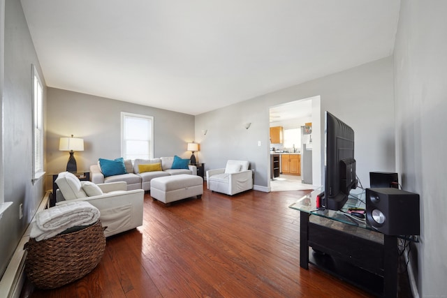 living room with baseboards and dark wood-type flooring