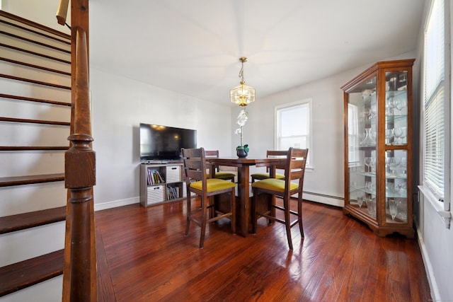 dining space featuring a baseboard heating unit, stairway, wood-type flooring, an inviting chandelier, and baseboards