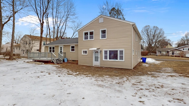 snow covered house featuring a deck