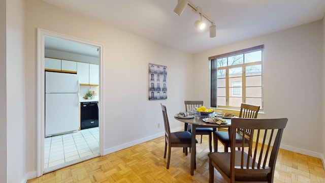 dining area with track lighting and baseboards