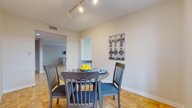 dining area featuring track lighting, visible vents, and baseboards